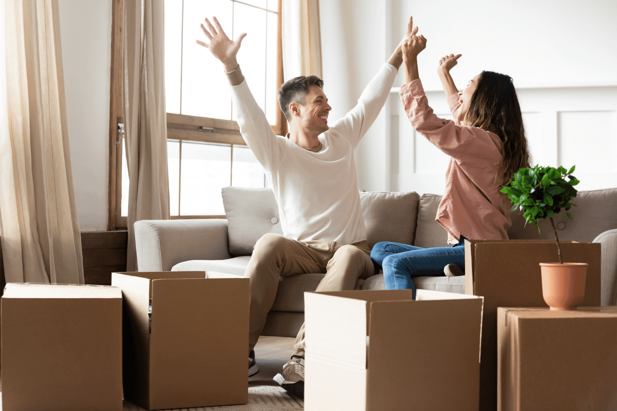 Happy couple celebrating among moving boxes in their new home